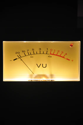 Close-up of a standard volt meter glowing softly on a wooden table.
