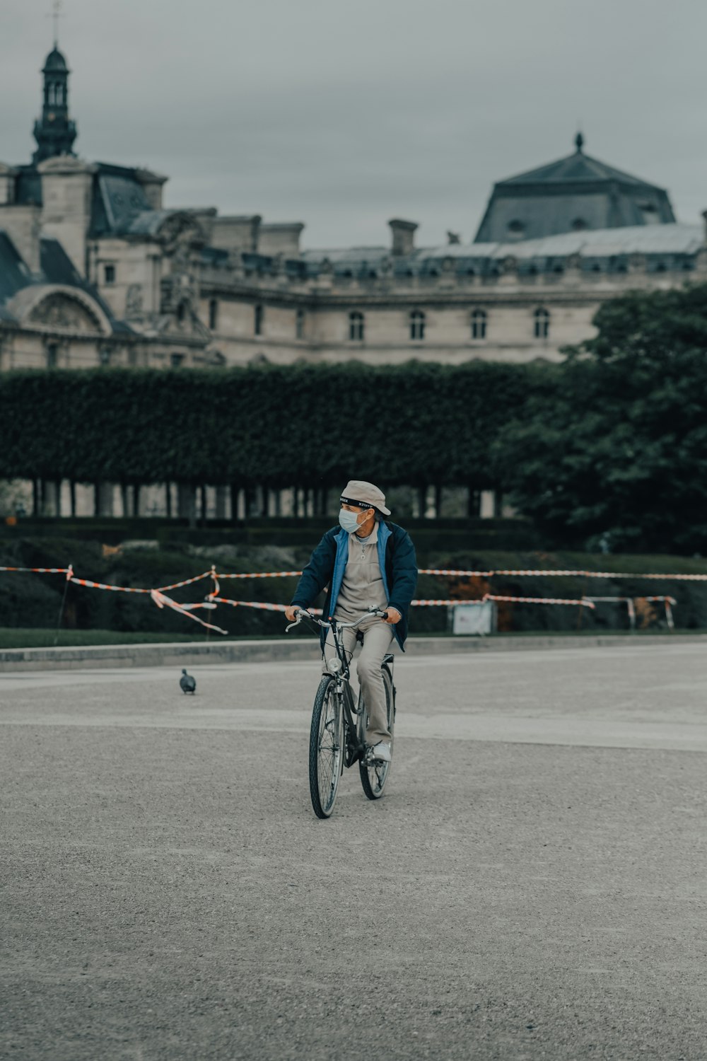 man in blue denim jacket riding bicycle on road during daytime