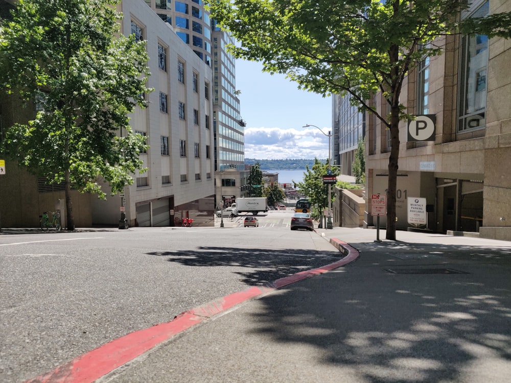 cars parked on side of the road near high rise buildings during daytime