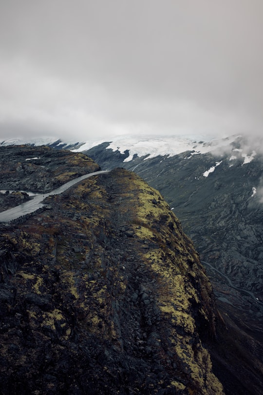 green and brown mountain under white clouds during daytime in Dalsnibba Norway