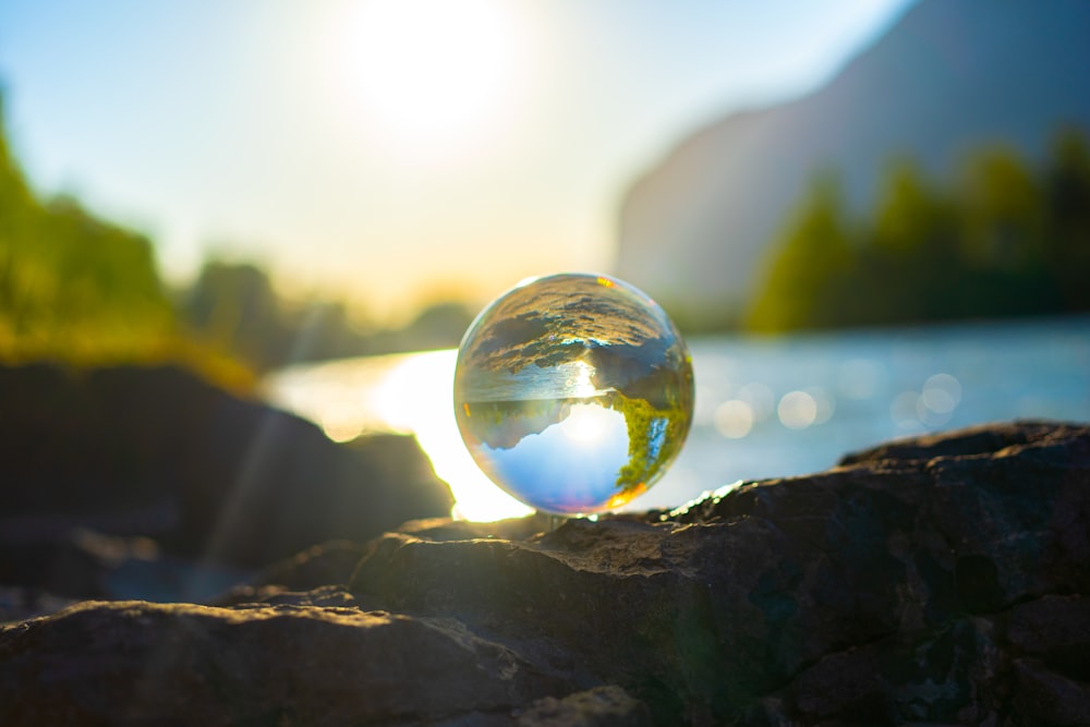 clear glass ball on black rock