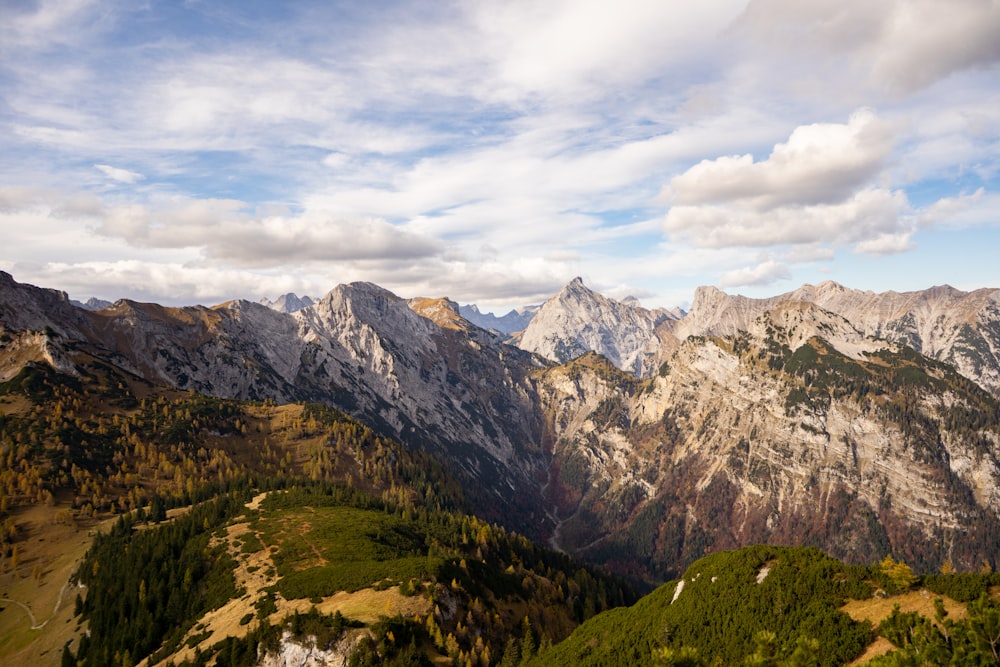 green and brown mountains under white clouds and blue sky during daytime