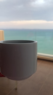 Close-up of a blank coffee mug ready for custom artwork, set against a soft cloud background.