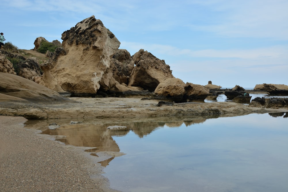 brown rock formation on body of water during daytime