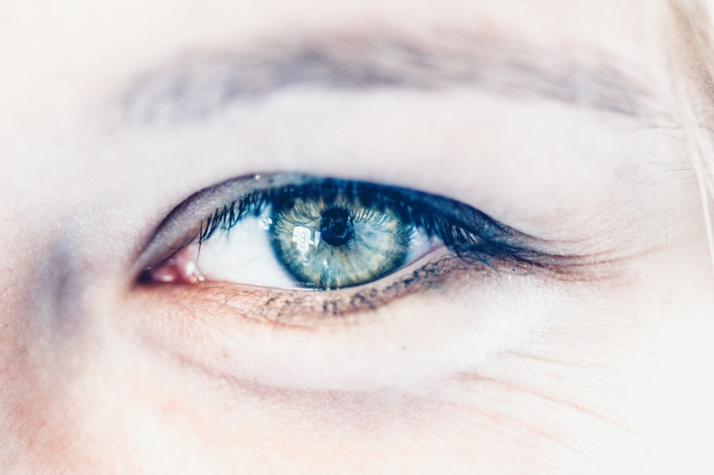 persons blue eyes in close up photography