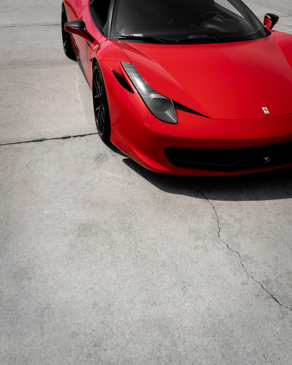 red ferrari 458 italia on gray concrete pavement