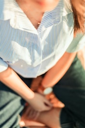 woman in white and blue stripe shirt and black pants