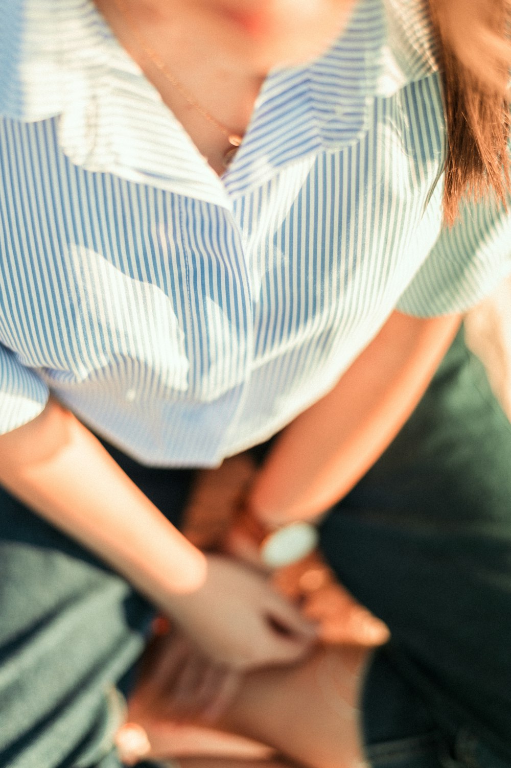 woman in white and blue stripe shirt and black pants