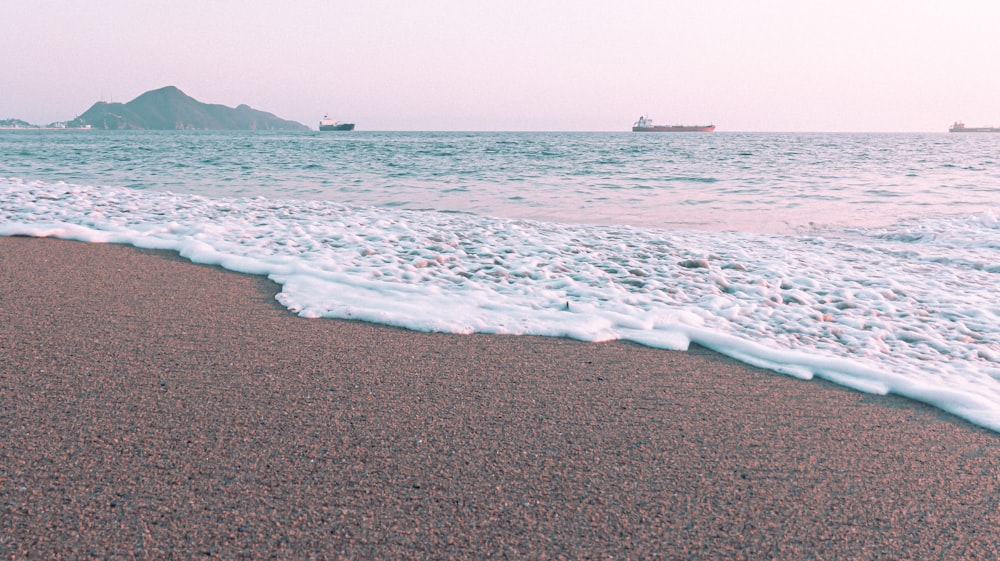 sea waves crashing on shore during daytime