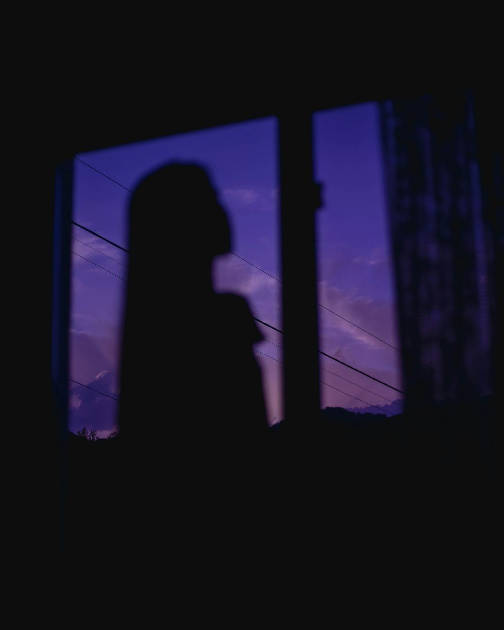 silhouette of woman standing in front of window