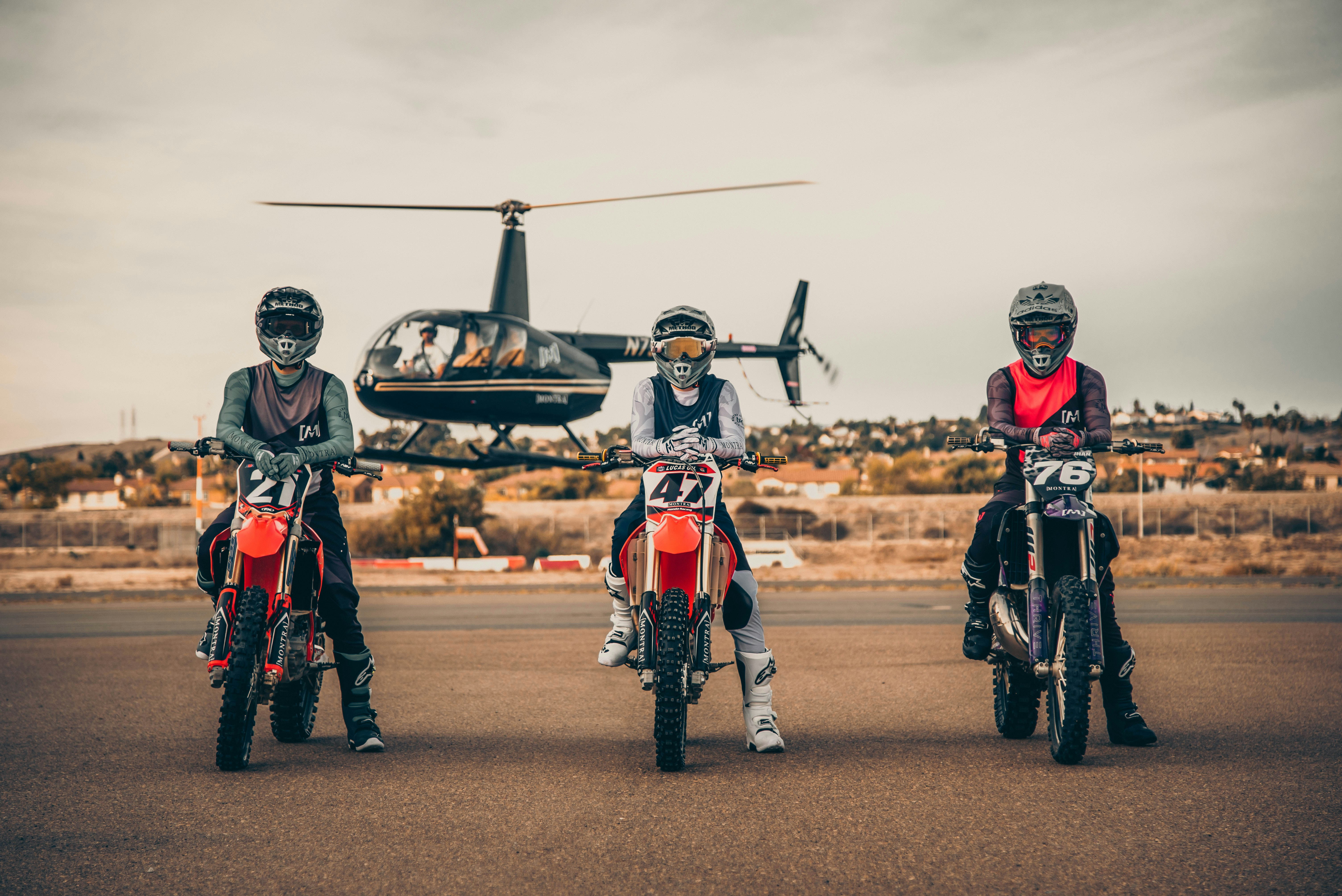 3 men in red and white suit holding black and white plane, 