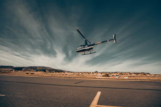 white and black drone flying over the road during daytime