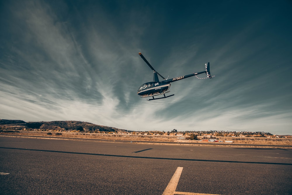 Drone bianco e nero che sorvola la strada durante il giorno