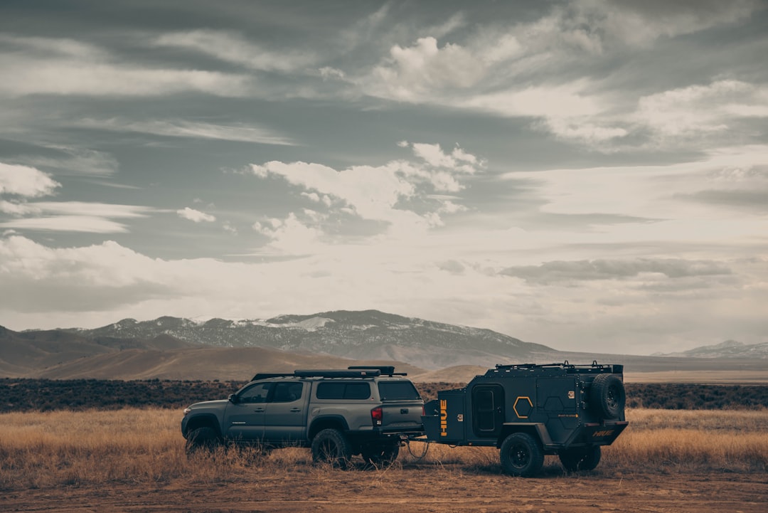 black suv on brown field under white clouds during daytime