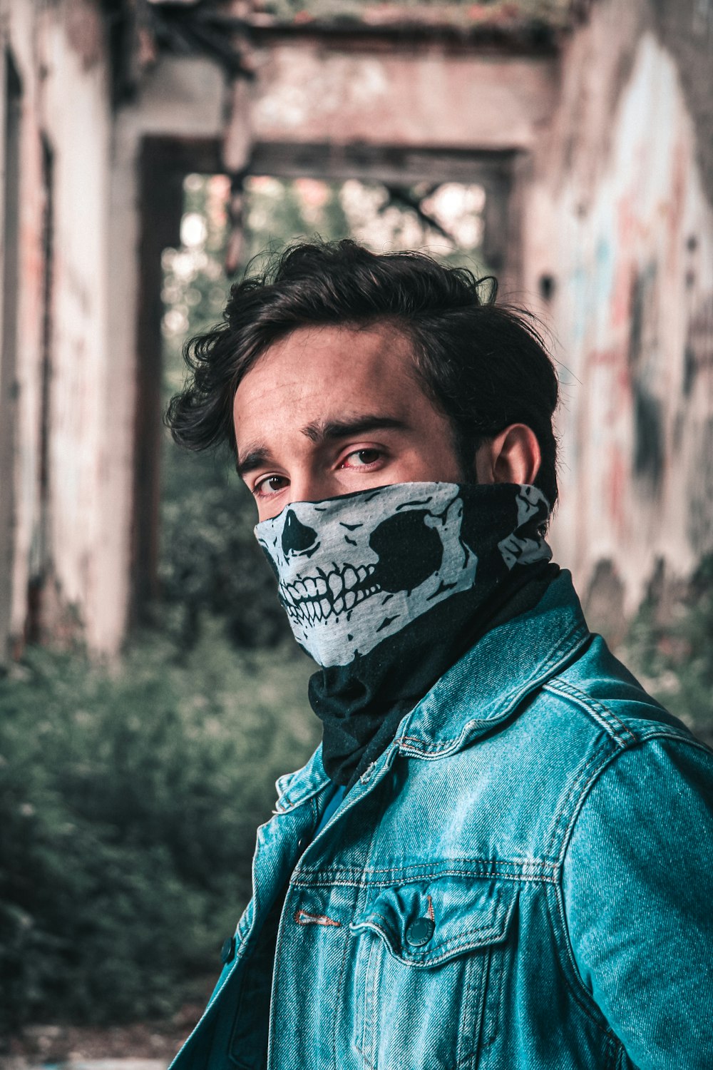 man in blue denim jacket with white and black skull face paint