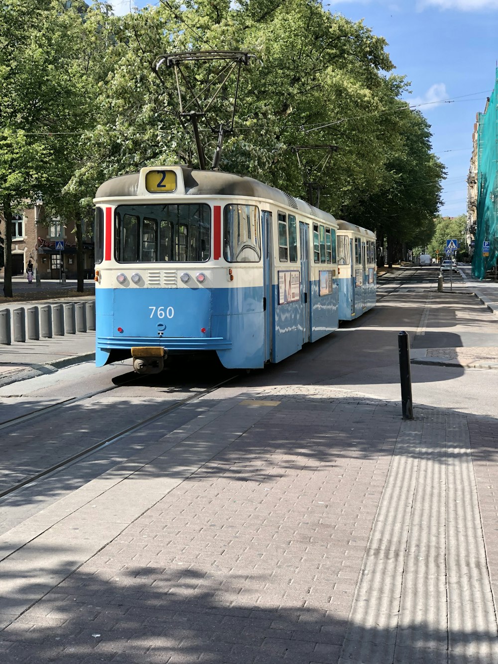 昼間の鉄道を走る青と白の列車