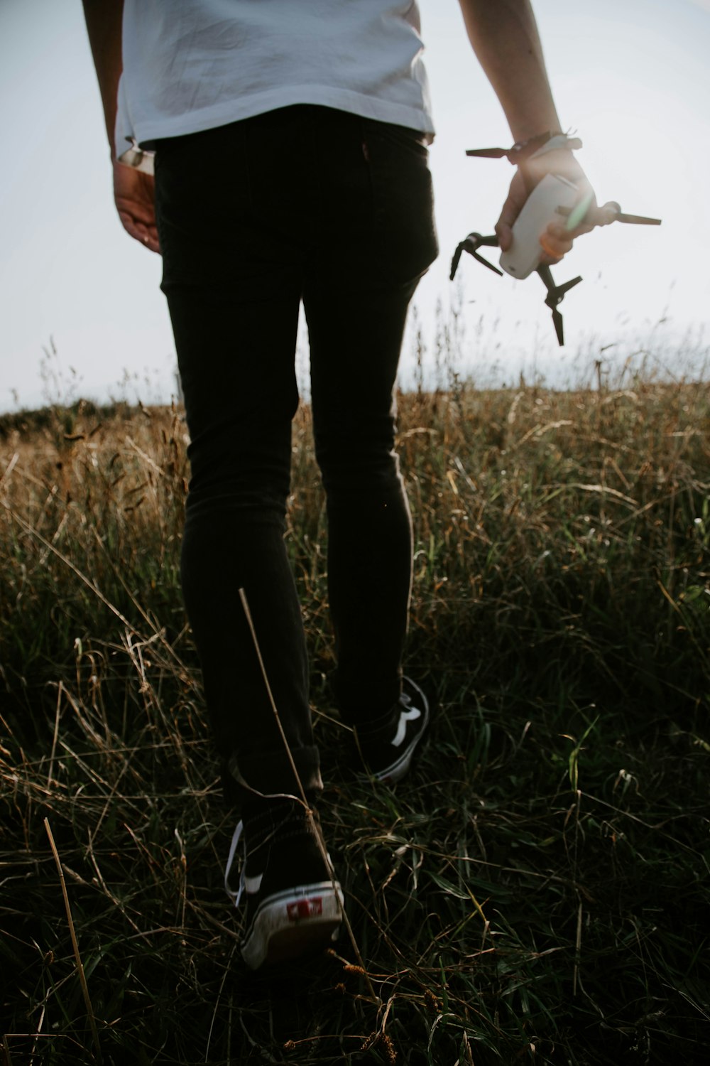 person in black pants and black shoes standing on green grass field during daytime