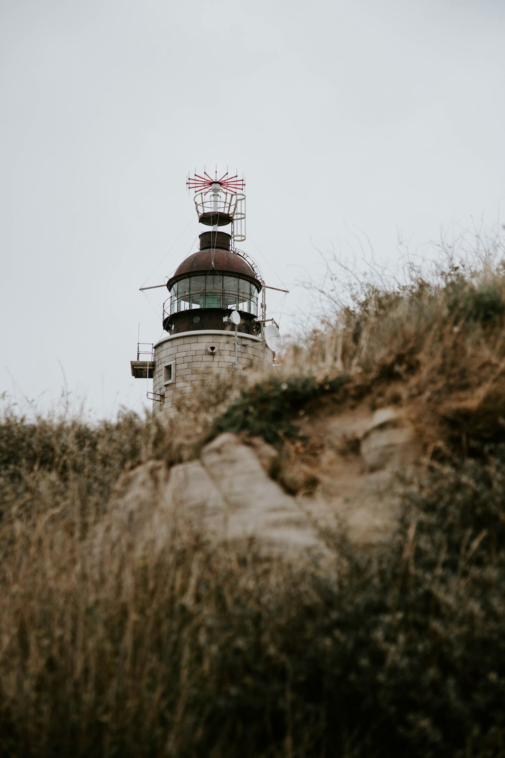 white and red lighthouse on brown grass field