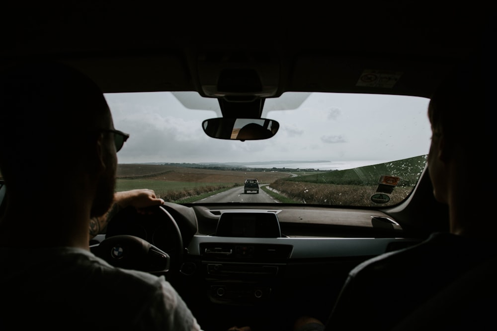 man in white dress shirt driving car during daytime