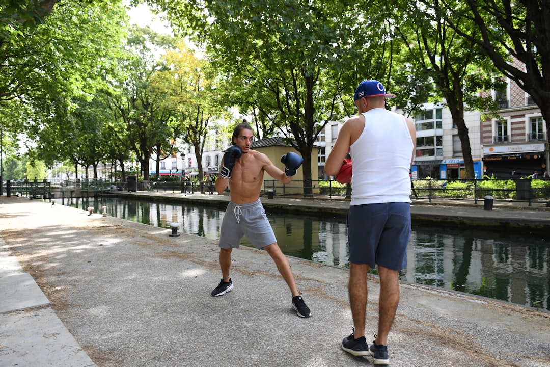 man in white tank top and gray shorts playing basketball during daytime