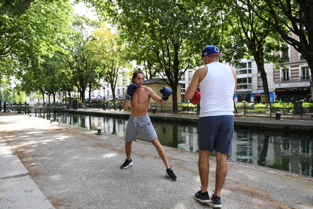 Mann in weißem Tanktop und grauen Shorts beim Basketballspielen tagsüber