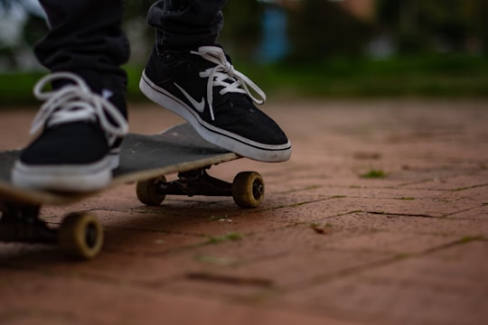 person in black and white nike sneakers riding skateboard in Bogota Colombia