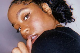 A close-up of a woman looking slyly over her shoulder, hinting at secrets.