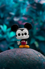 mickey mouse plush toy on gray rock