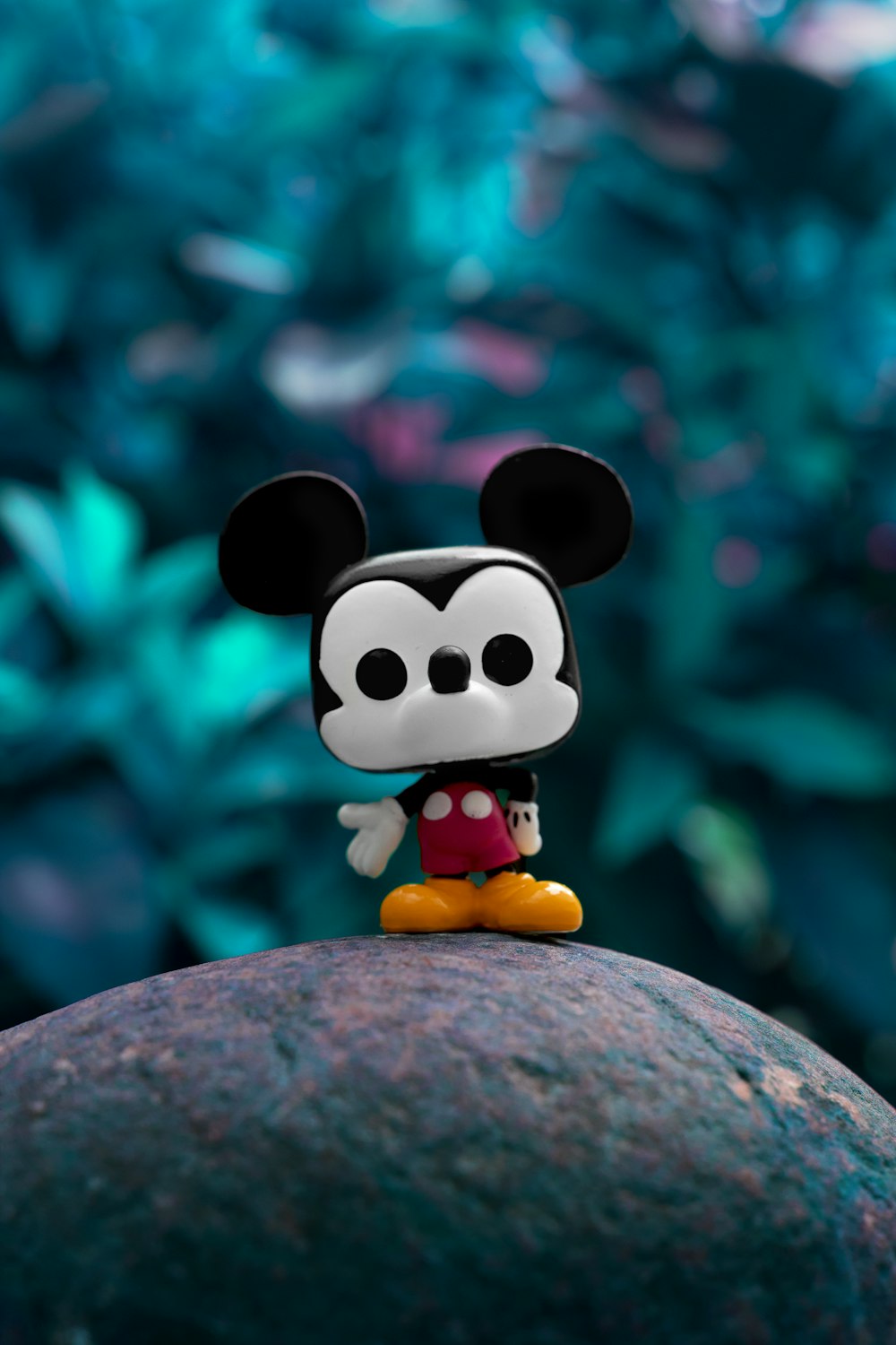mickey mouse plush toy on gray rock