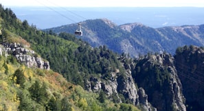 white cable car over green and brown mountain during daytime