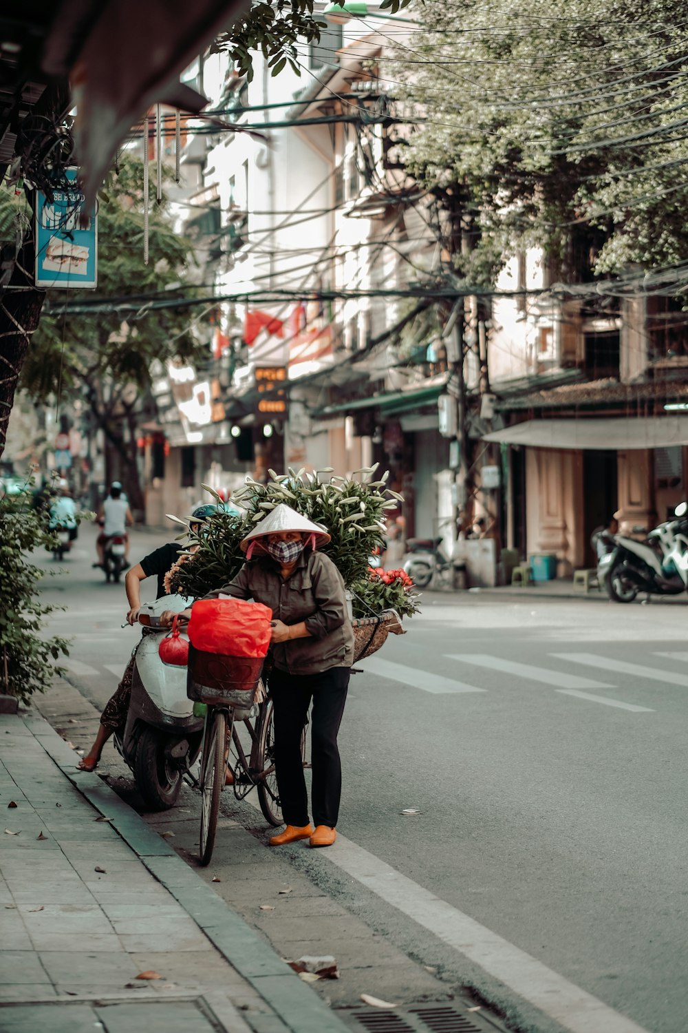 woman in red and white floral dress riding on bicycle on road during daytime