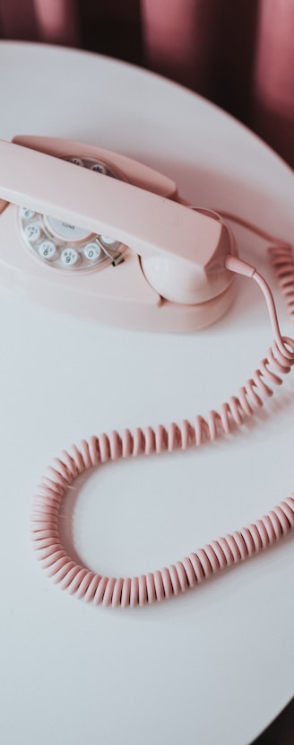 white and pink rotary phone