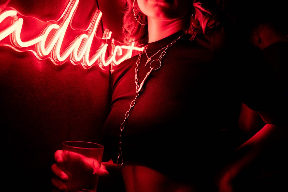 woman in black shirt holding clear drinking glass