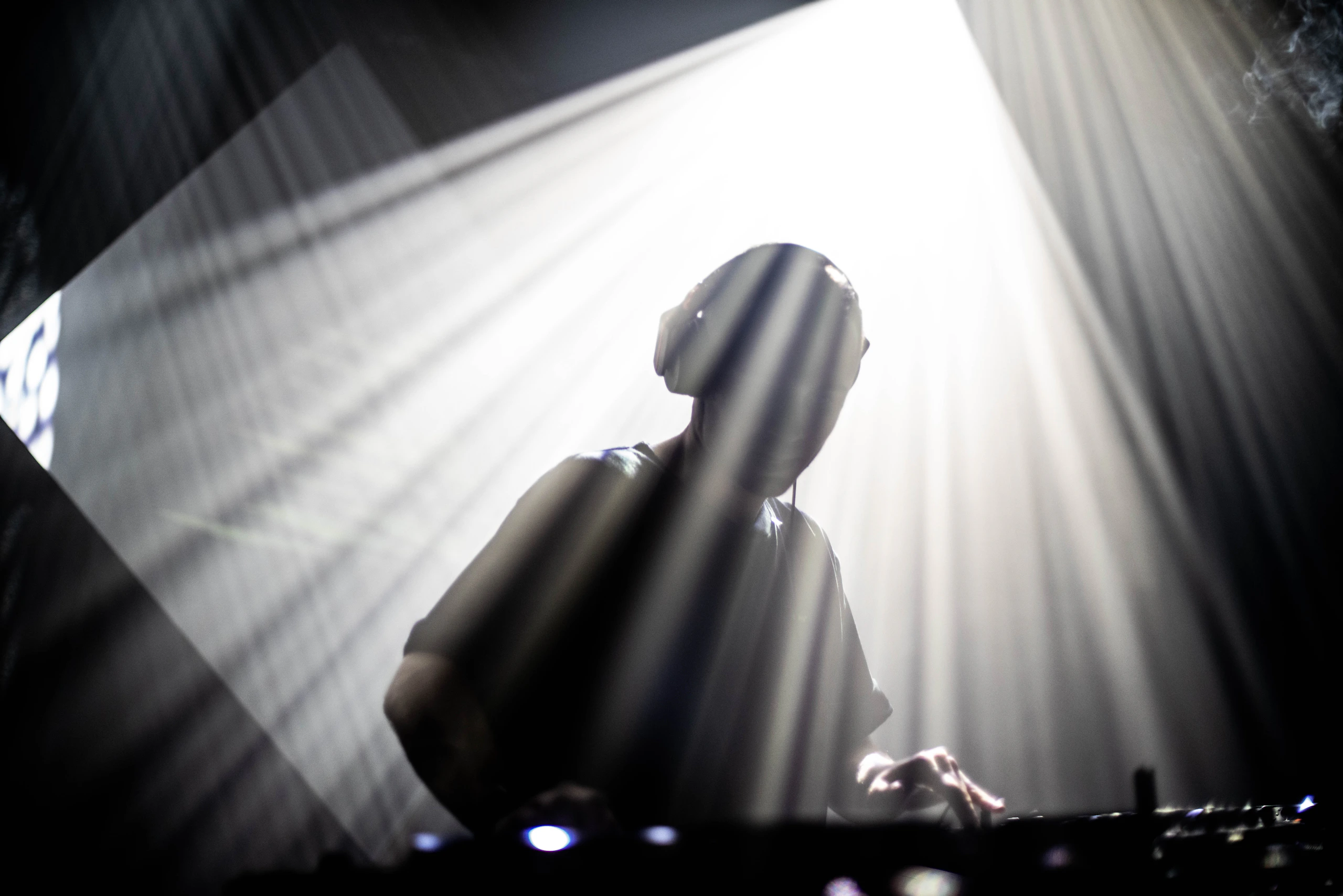 Placeholder image of a DJ silhouetted by stage lights. Replace with a portrait of DJ Shark