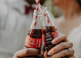 person holding coca cola bottle