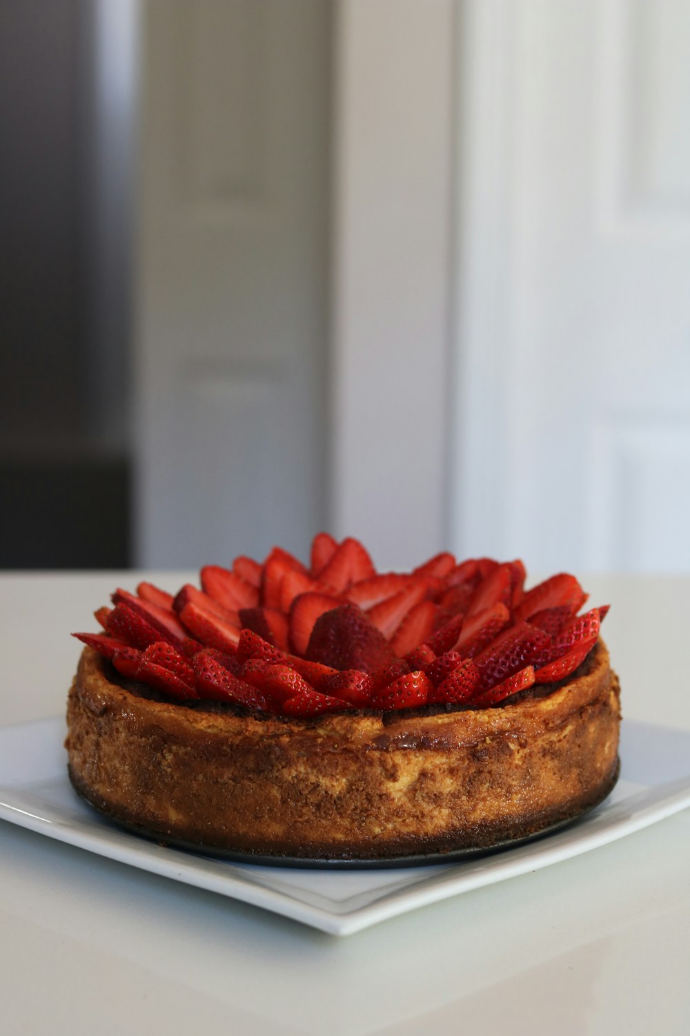 brown bread with red sliced strawberries on white ceramic plate