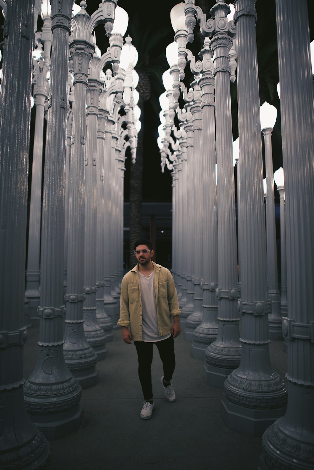 man in brown coat standing on gray concrete floor