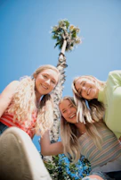3 women smiling and standing under blue sky during daytime