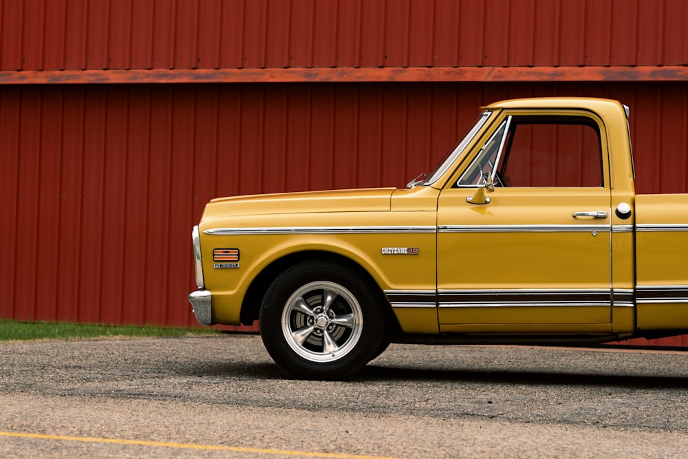 yellow car parked beside red wall