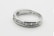 A silver ring with a row of seven small, sparkling diamonds embedded along its band. The interior of the band is inscribed with '14K'. The ring is simple yet elegant, showcasing a minimalist design.