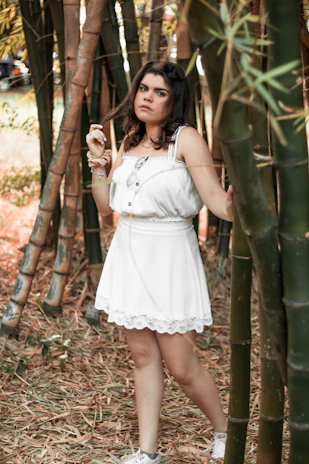 Model wearing a flowing dress made from bamboo fabric in a serene outdoor setting.