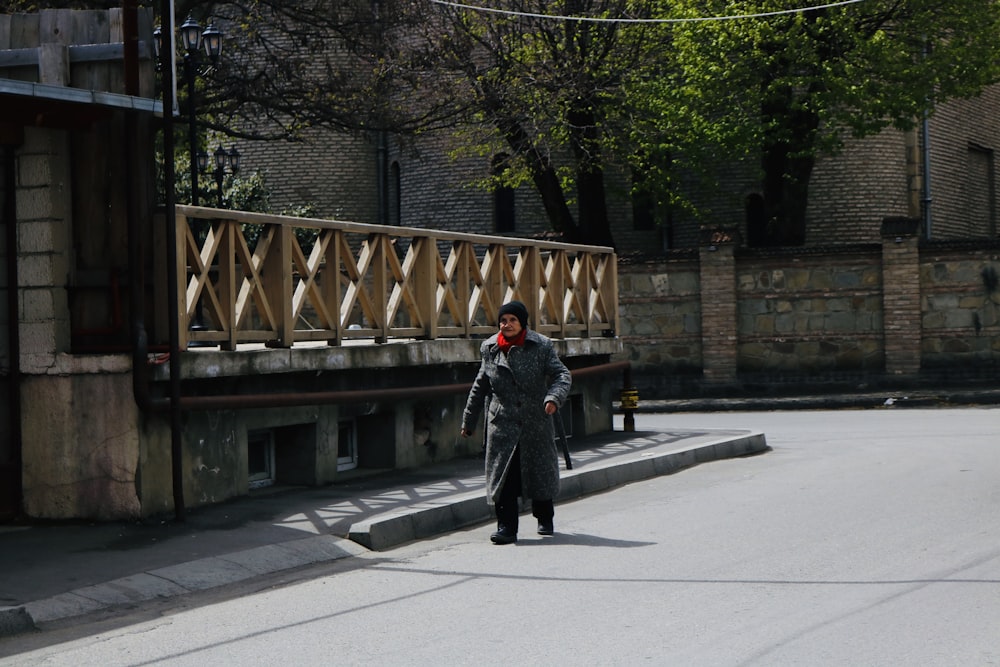 man in black jacket walking on sidewalk during daytime