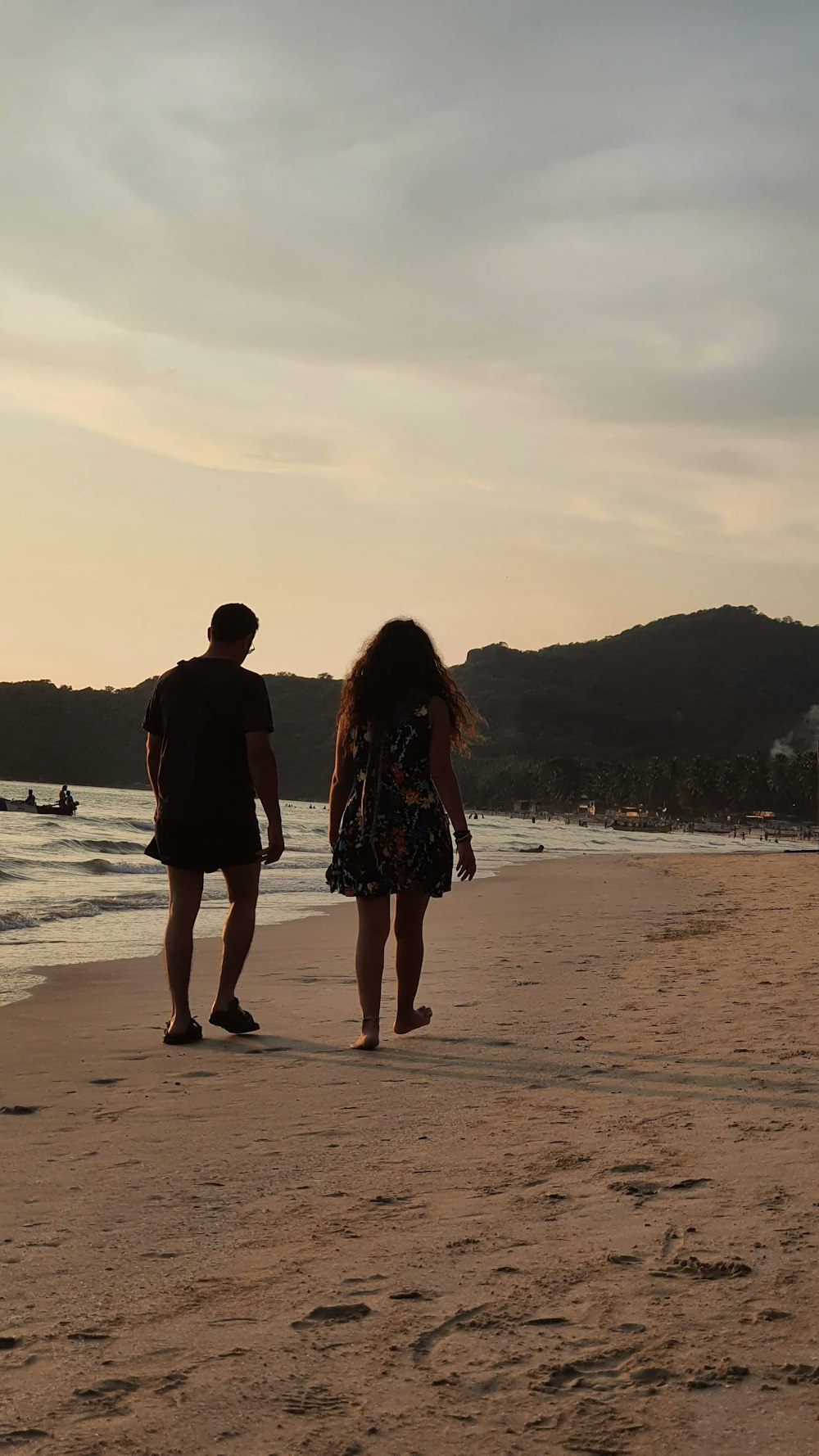 couple walking on beach during sunset