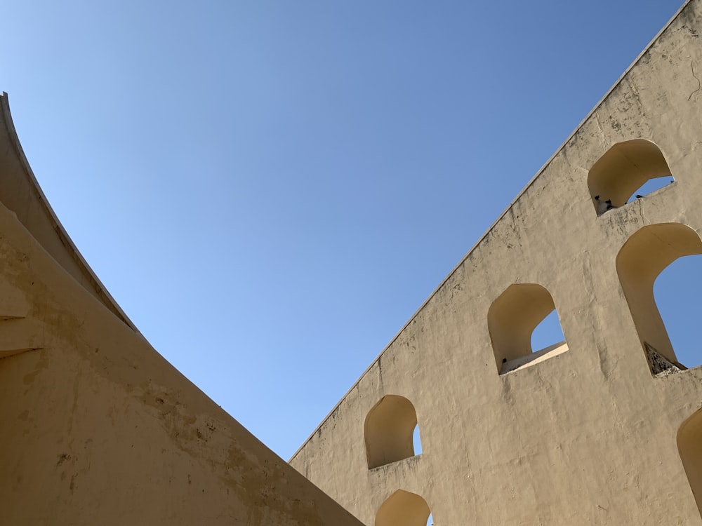 low angle photography of brown concrete building under blue sky during daytime