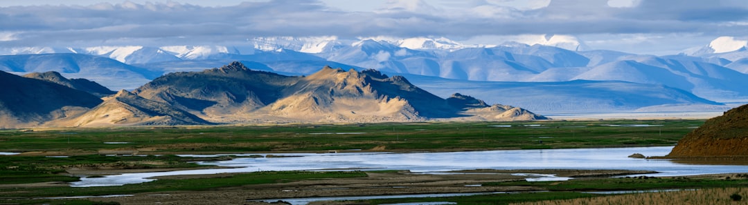 brown and white mountains under white clouds during daytime