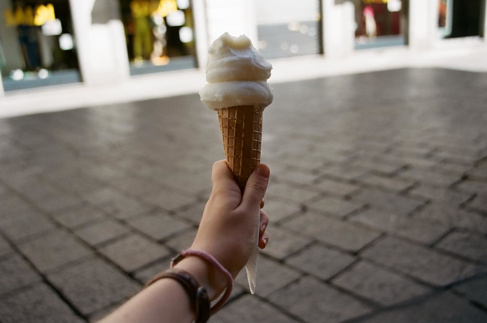 personne tenant un cornet de crème glacée