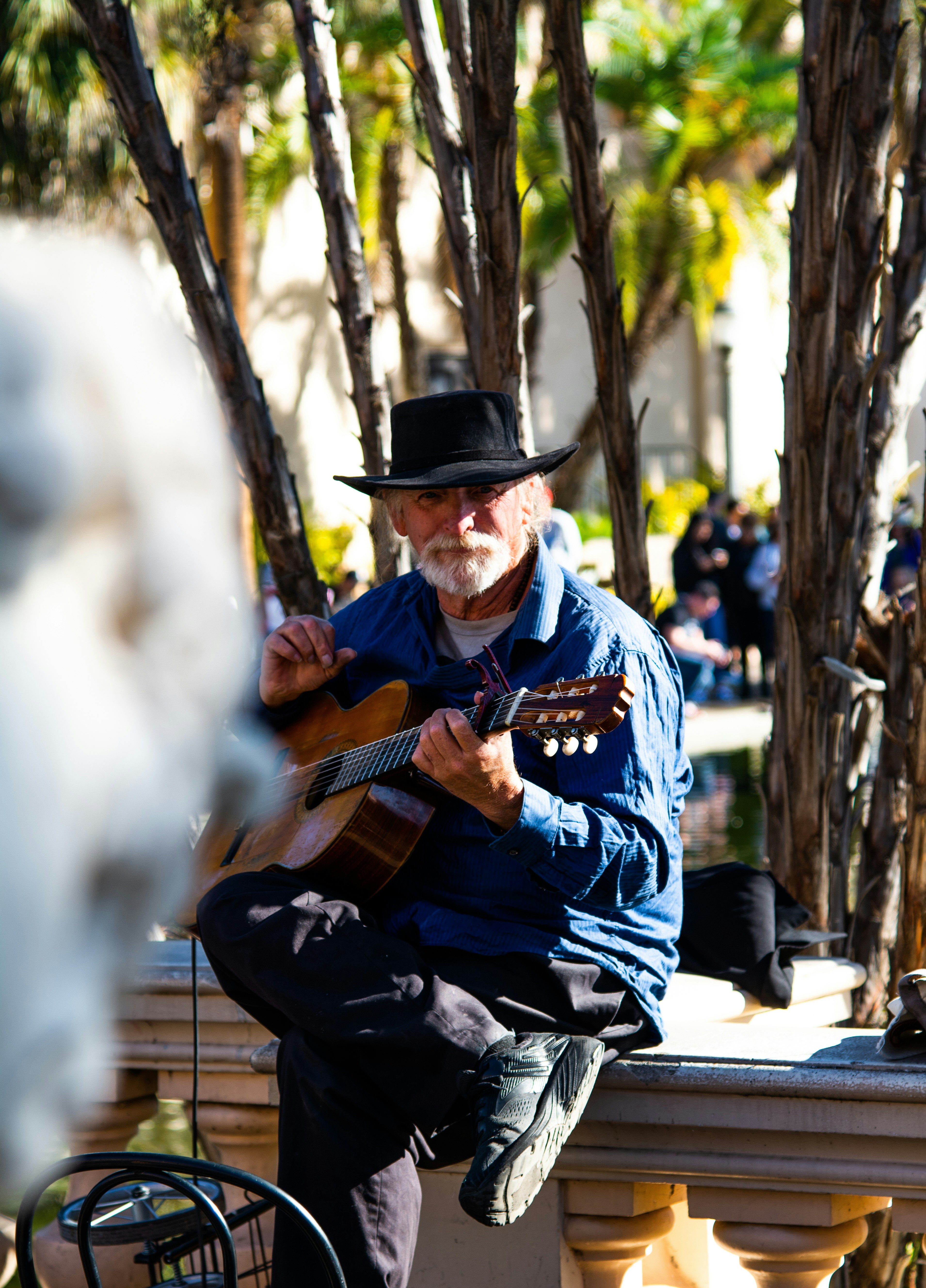man in blue and white crew neck t-shirt playing guitar