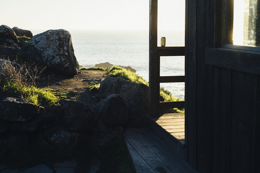 brown wooden fence near body of water during daytime