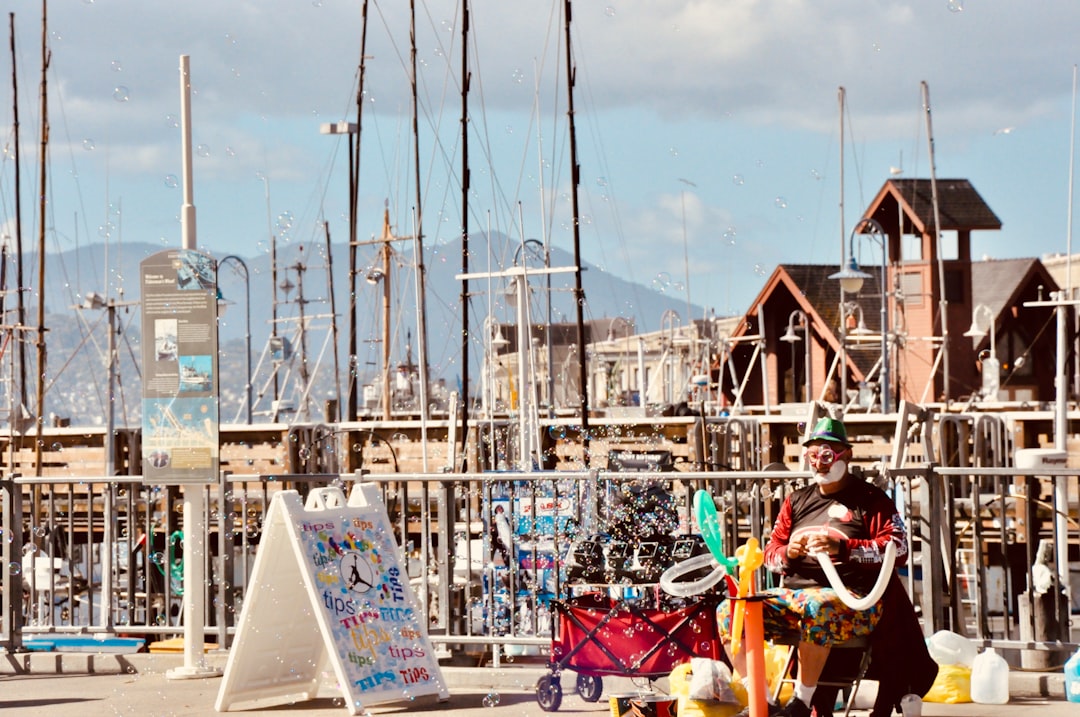 man in red shirt sitting on white boat during daytime