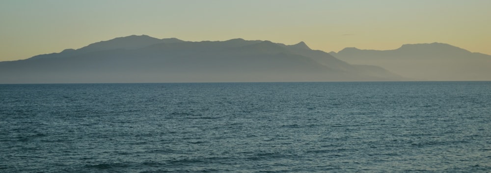 a large body of water with mountains in the background